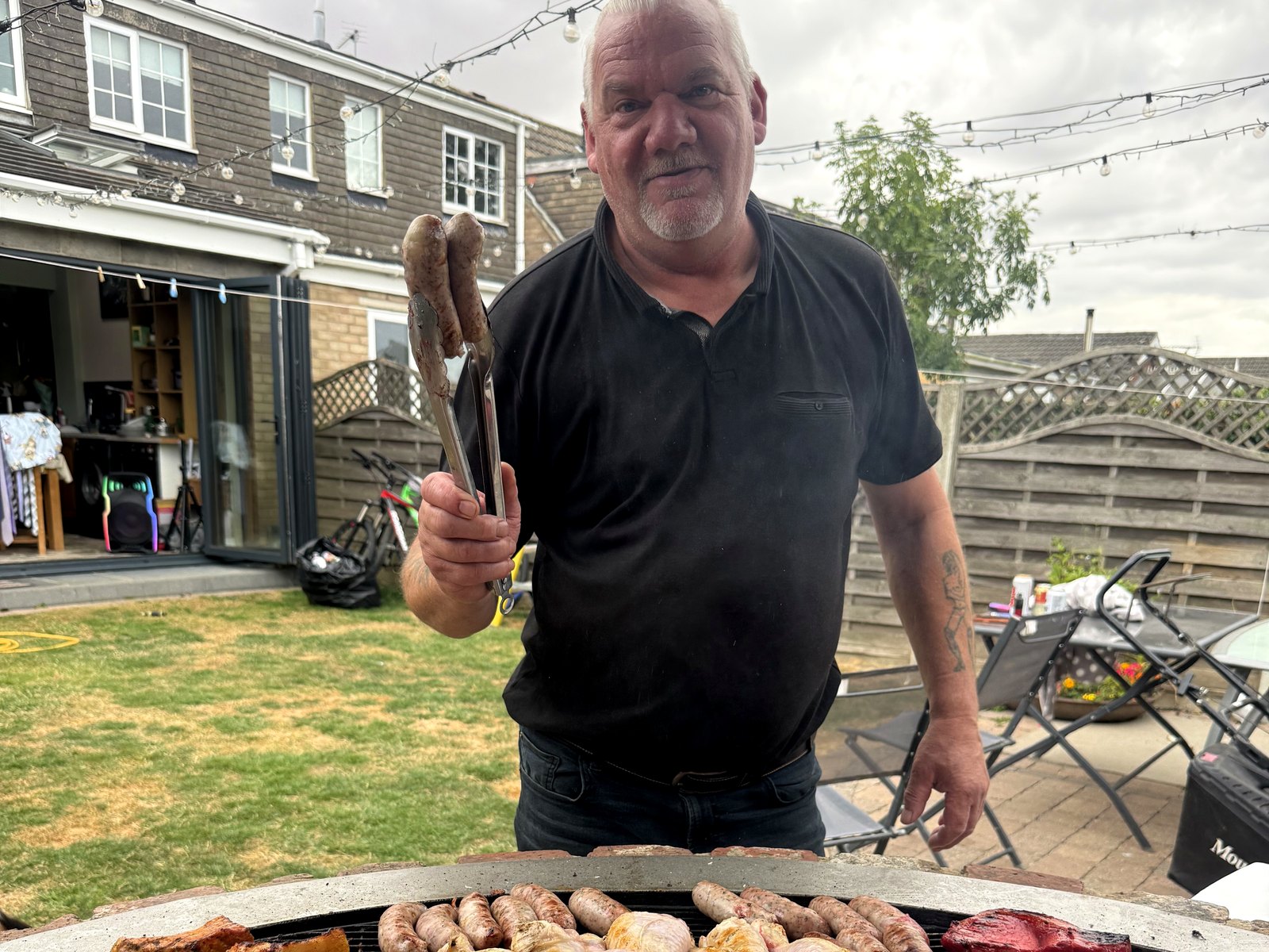 Stu at the grill with a full spread of his meat