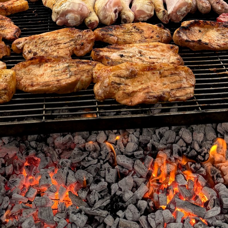 Rows of Stu's sausages and chicken on the coals