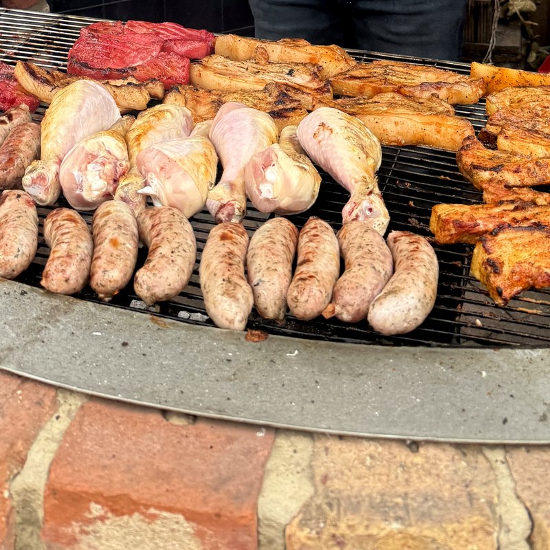 Sausages, chops and chicken cooking over fire